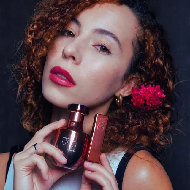 Ludy Paim, criadora de vídeos UGC brasileira, segurando um perfume em um vídeo de produto
